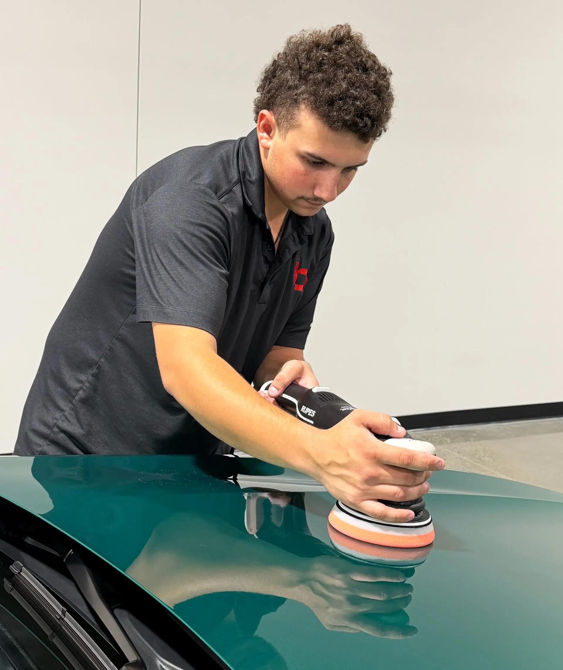 A crew member polishing a hood